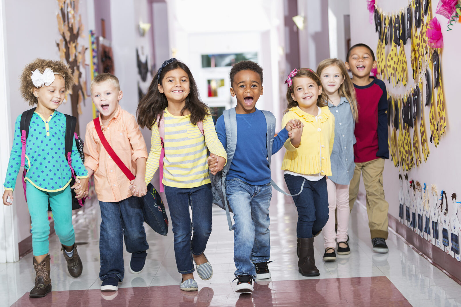 Elementary school students walking together down a school hallway